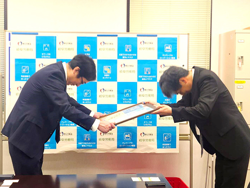 「新はつらつ職場づくり宣言」登録証を受け取る宇野直司理事長